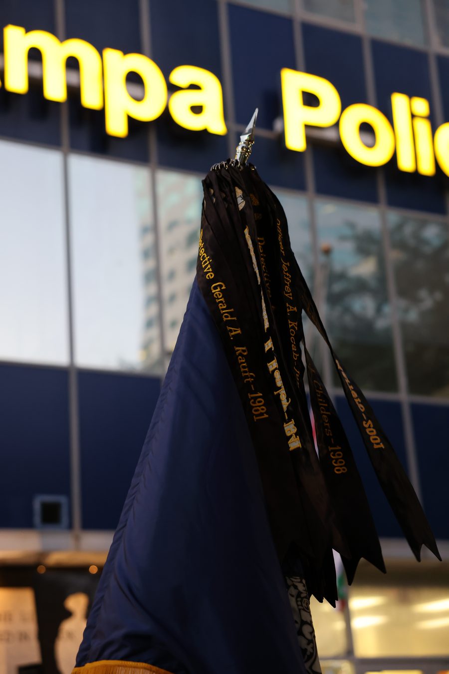 Memorial streamers bearing the names and end-of-watch years of fallen Tampa officers, outside Tampa Police headquarters